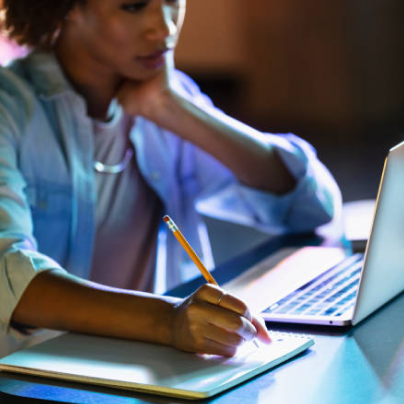 women taking notes in front of a computer